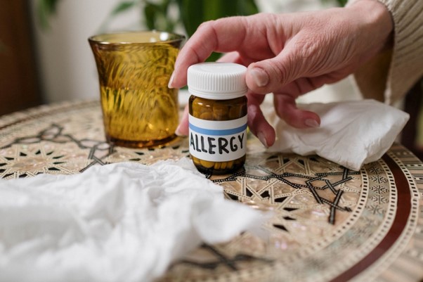 Featured image of a person about to take a medicine featured in the article - Achoo, No More! Navigating Common Allergies with Ease