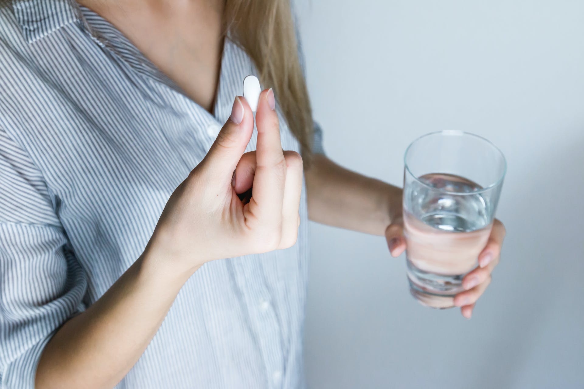 A women about to take a tablet featured image of article on how long does ibuprofen take to work - published on healthy n better living